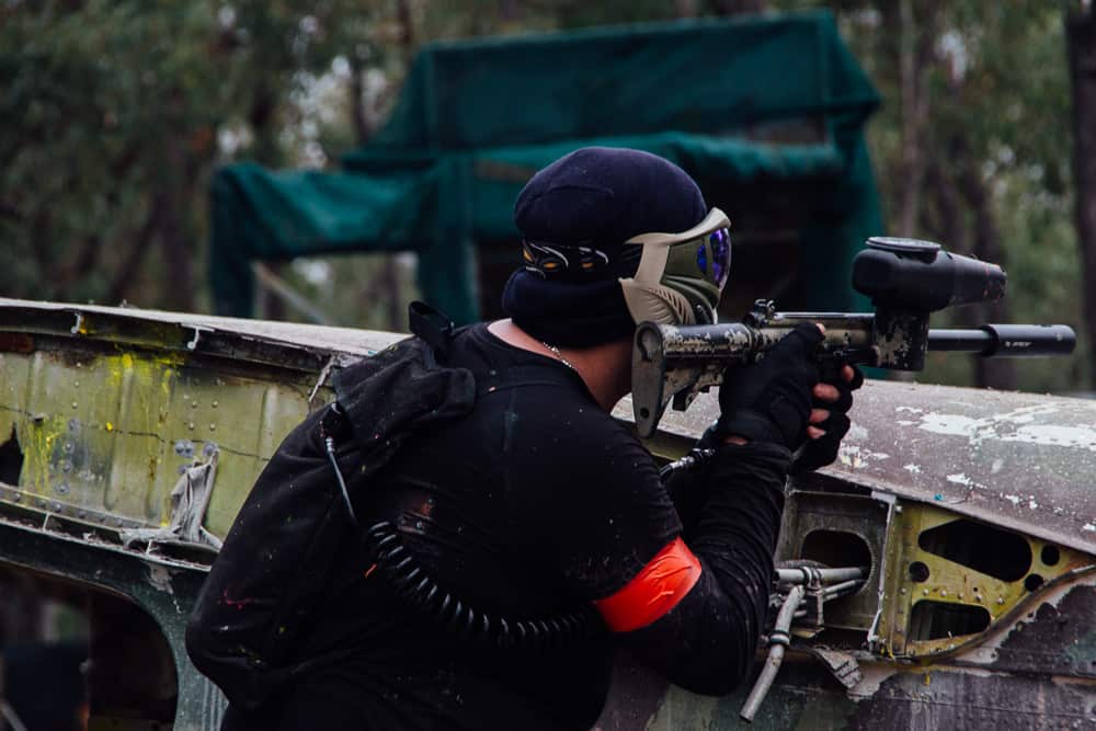 Paintball player hiding behind an obstacle