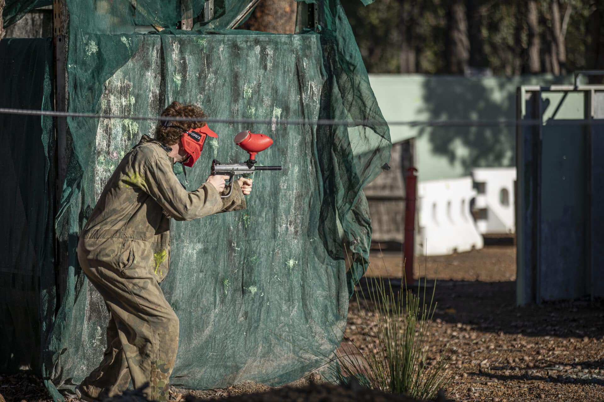 Paintball player hiding behind a barricade