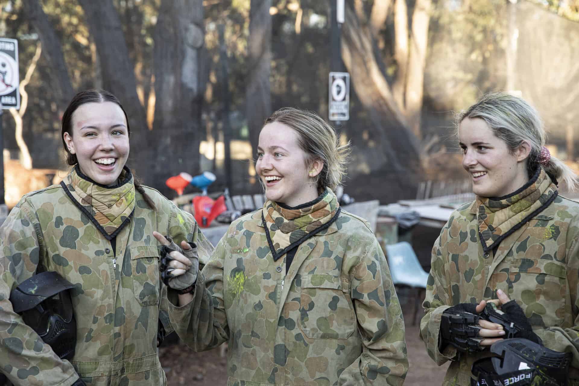 Group of young ladies laughing after paintball game