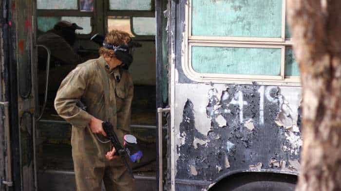 Paintball player taking cover in bus doorway
