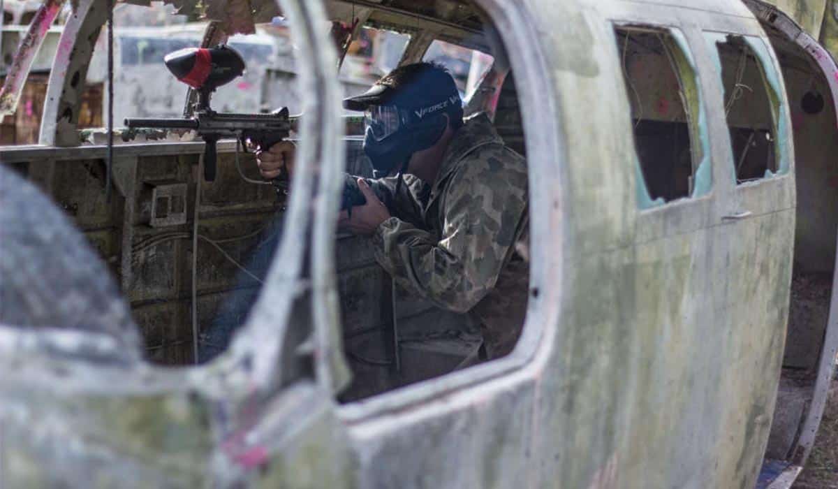 Paintball player hiding inside an aeroplane obstacle